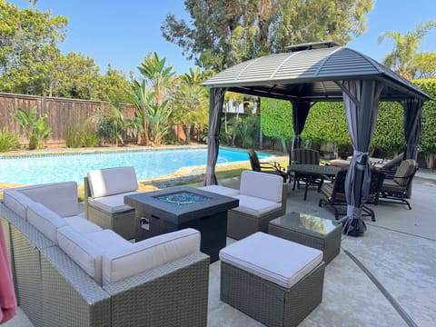 Cushioned outdoor seating areas around the fire pit and inside the gazebo   