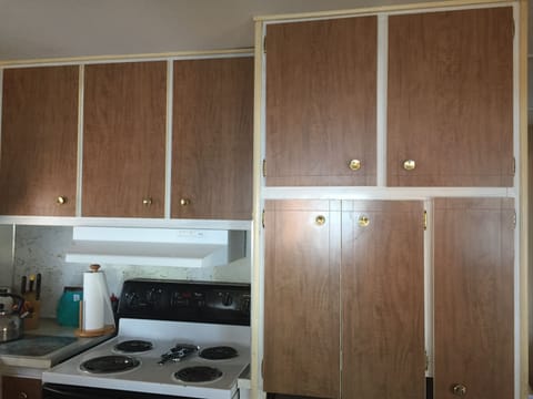 Kitchen is well equipped with major appliances, sink, pans, dishes, and more.