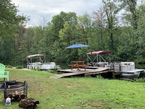 Back yard of cottage. Bonfire pit, and dock on the channel