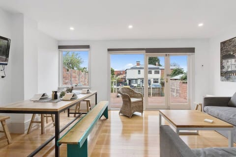 The open-plan dining area, flooded with natural light, offers a stylish and comfortable space to enjoy meals.