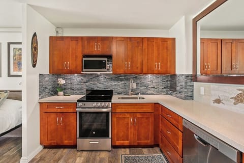 Whip up island favorites in this updated kitchen, complete with a stunning tile backsplash, sleek countertops, and stainless steel appliances.