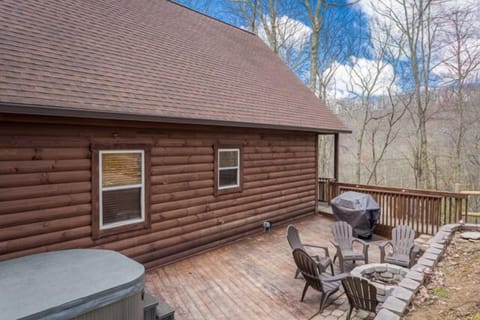This deck equipped with a hot tub, grill and fire pit.