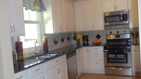 Fully equipped kitchen with classic ceramic tile backsplash & tile floor.