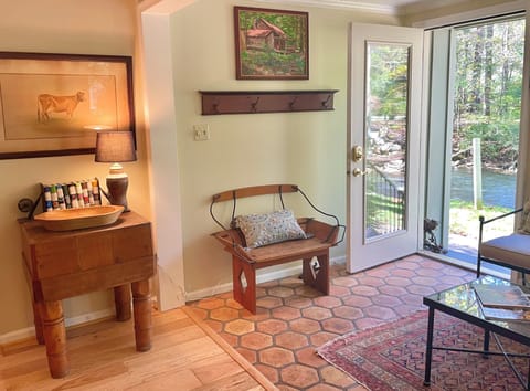 Guests enter the cabin past a vintage butcher block and old carriage bench.