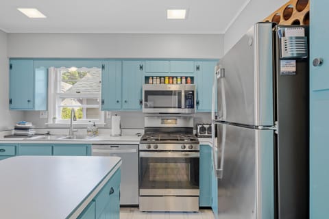 Kitchen is stocked with pots, pans, towels, spices, and other helpful items