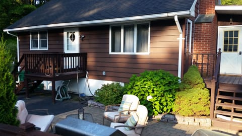 Front of home, patio, and ramp door leading to enclosed porch