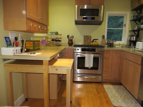 Bright kitchen with gas stove /oven and microwave. Table slides under counter!