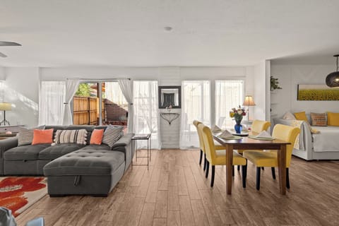 Open-plan main room: sectional, dining, daybed, patio sliders.