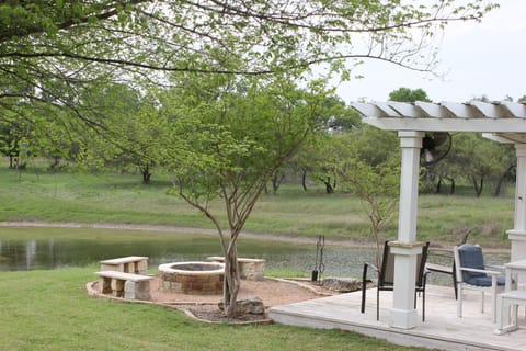 Peaceful setting beside house and pond. Firepit and covered pergola and sink.