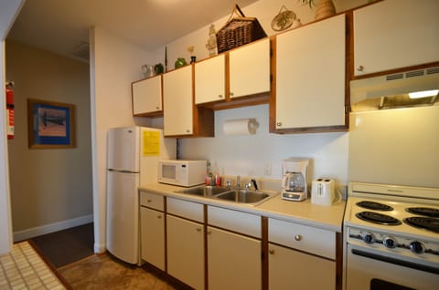 Galley kitchen with ceramic tile floor and open pass through to dining area