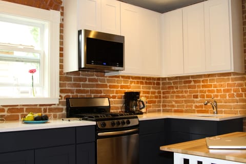 A cozy updated kitchen with historic exposed brick.