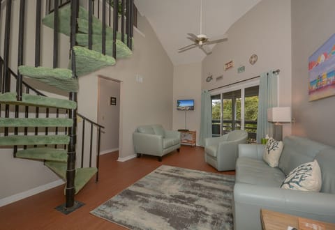 Open living room with vaulted ceilings and stairs to the loft.
