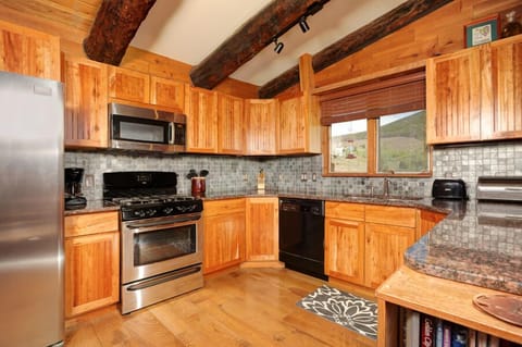 Full kitchen on top level with granite countertops and stainless steel appliances.