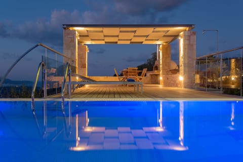 Pool terrace features outdoor shower, shaded dining area with a wood stove