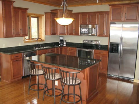 Full kitchen with granite countertops & stainless steel appliances.
