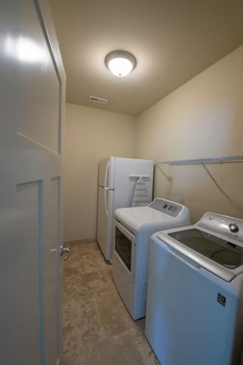 Laundry room with a full size refrigerator, washer and dryer. Plus Iron and ironing board