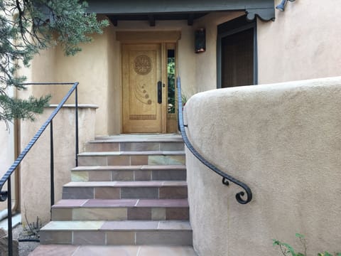 Sandstone steps leading to hand carved front door.   