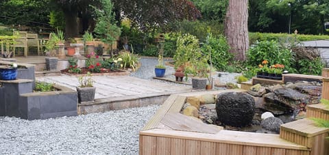 View up the garden, BBQ area at rear and pondless water feature in foreground,