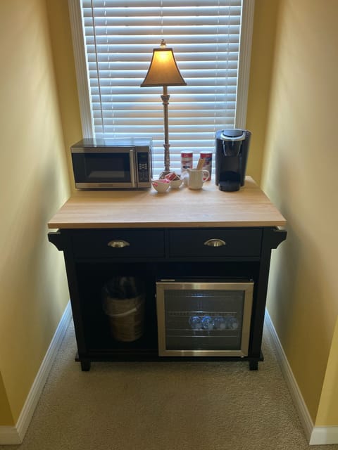 Coffee bar fridge, microwave , and Keurig coffee maker and chilled bottled water