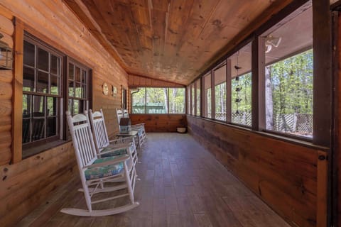 front porch - Unwind on the spacious screened porch, complete with rocking chairs, warm wood accents, and peaceful woodland views. The perfect spot to enjoy your morning coffee, a good book, or a quiet evening surrounded by nature.