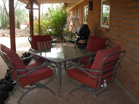 Veranda with table for lounging and eating, swing, and grill