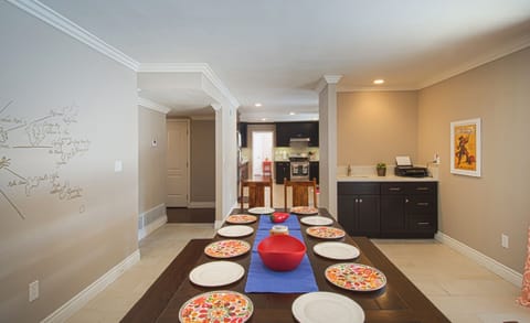 - Dining room with long wooden table and seating for large groups   - Open design connects easily with kitchen for shared family meals   - Spacious setup ideal for gatherings and vacation celebrations