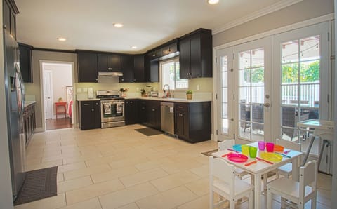 - Bright open kitchen with stainless steel appliances and backyard view   - Family-friendly setup with dining area and access to outdoor patio   - Spacious design makes it easy to prepare and share vacation meals