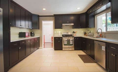 - Kitchen with dark cabinets and modern stainless steel appliances   - Spacious layout provides plenty of room for cooking family meals   - Fully equipped design perfect for group dining and entertaining