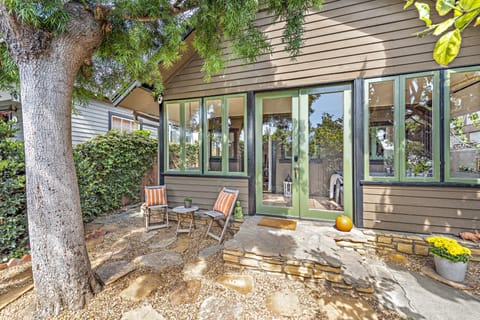 Front courtyard with sitting area surrounded by trees and flowers. 