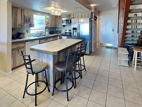 Fully Equipped Kitchen with Stainless Steel Appliances and Breakfast Bar Seating for Four