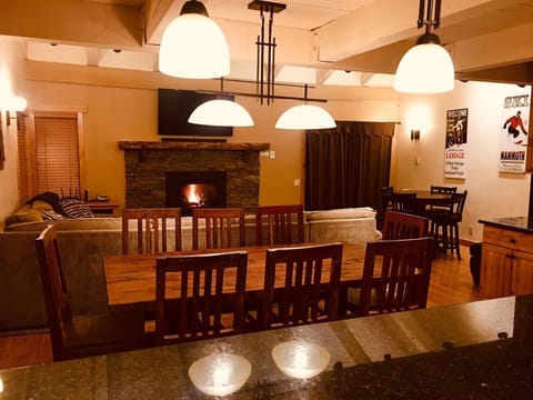 Main level living room, dining area, fireplace, game table, door to balcony.