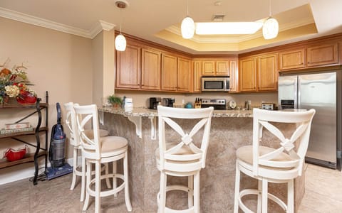This kitchen features warm wood cabinetry, granite countertops, and a cozy breakfast bar, perfect for morning coffee