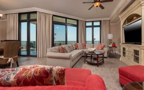 The living area features a plush sofa, vibrant red accents, and a large TV, perfect for relaxation with a state park view