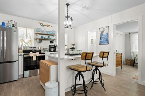 Open kitchen with eat-at-island and drop-leaf table for additional dining.
