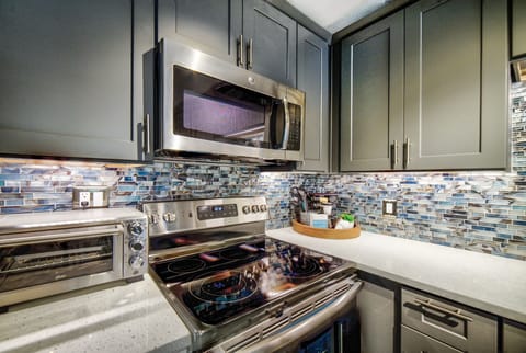 Stainless steel appliances throughout. Spice rack with salt and pepper grinder. 