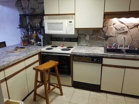 Kitchen with marble countertops and stone backsplash.
