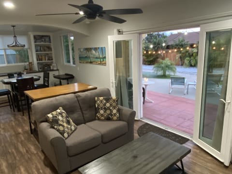 Living space with French doors to back yard patio and shuffle board.