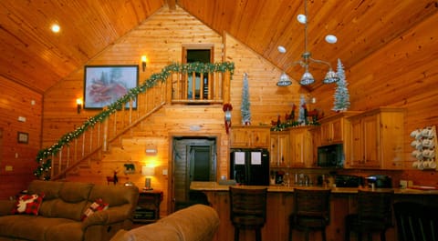 Christmas décor looking from wall of windows toward stairwell and kitchen.