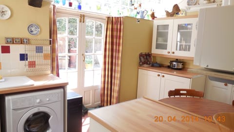The kitchen,the sun shines through the coloured glassware above the french doors