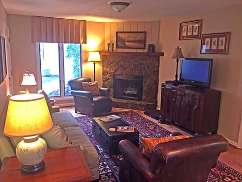 Living Room with Couch, Two Leather Arm Chairs & Gas Fireplace