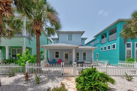 Bright beach house surrounded by colorful neighbors and swaying palms creates the perfect coastal getaway atmosphere.