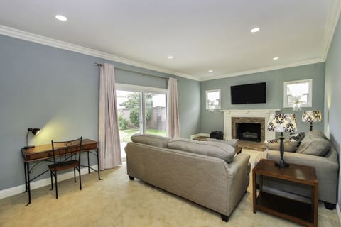 Spacious living room with wall mounted TV equipped with Roku - Netflix, Disney