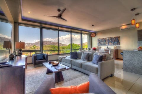 - Modern living room with panoramic mountain views   - Floor-to-ceiling windows flood space with natural light   - Relax in plush seating with flat-screen TV and sleek decor