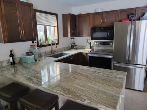 Kitchen with new stainless steel appliances and well stocked 