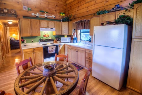 Real wagon -wheel table in fully stocked kitchen.