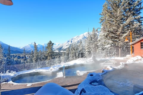 Unwind in the soothing warmth of a mountain hot spring, surrounded by crisp alpine air and breathtaking snowy peaks.