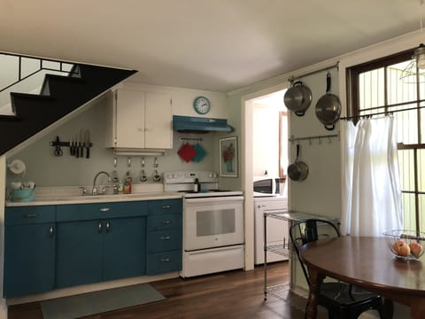 The vintage style kitchen is stocked with pots, pans, utensils, and dishes