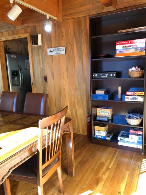Dining room has large bookshelf with a variety of games and puzzles 