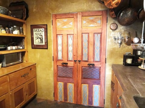 Hand painted pantry doors lead to a powder room