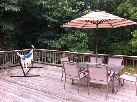Back deck with gas grills, hammock, table and chairs, and recliners. Swingset